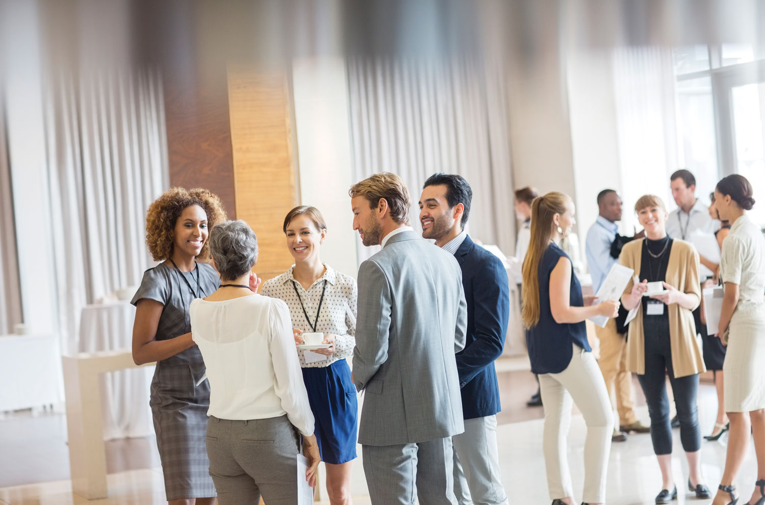 Businesspeople mingling at conference over coffee