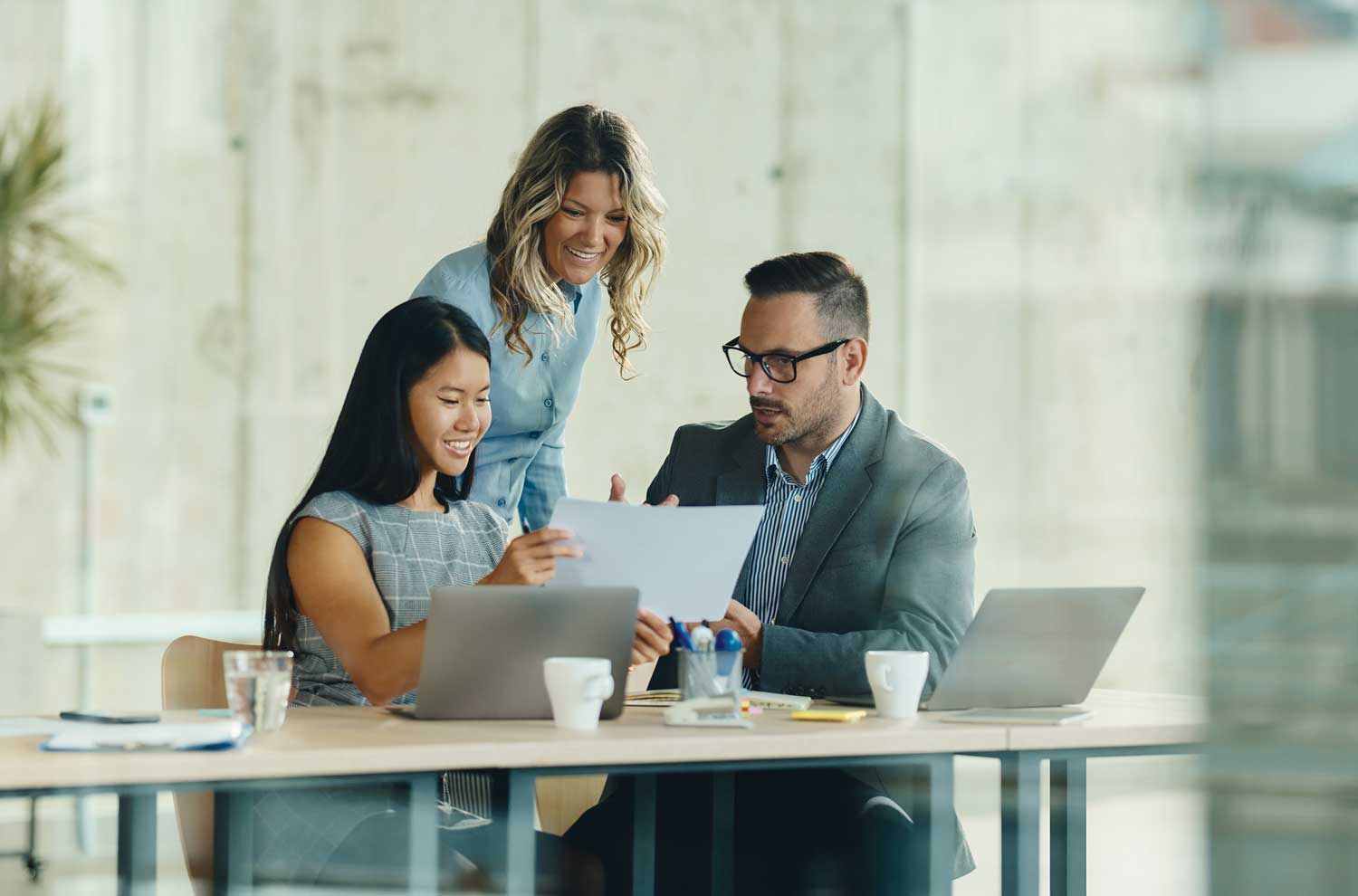 Three businesspeople reviewing paperwork together